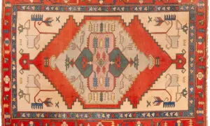 Tappeto turco con motivi geometrici e stilizzati di animali e alberi in colori vivaci.