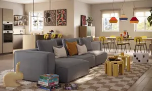 Un divano grigio moderno, con cuscini colorati, è il protagonista. Accanto, giochi da tavolo e una scultura a forma di coniglio. Ottime idee su cosa mettere dietro al divano per un tocco di stile.