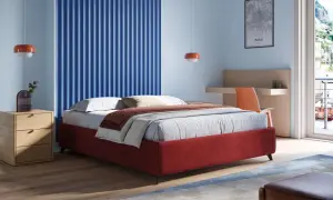 Un letto sommier rosso, con comodino in legno e parete blu a coste. Un'idea di design moderno per la camera.