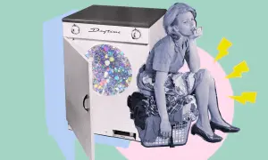 Donna annoiata seduta su un cesto di panni, accanto a una lavatrice con glitter. Un'idea su come disinfettare i vestiti senza lavarli.