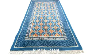 Tappeto cinese blu con motivi floreali arancioni e bordi geometrici. Un pezzo d'arte che porta un tocco di eleganza orientale.