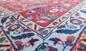 Tappeto Tabriz usato, con dettagli floreali rossi e blu su fondo chiaro. Ottimi prezzi per questo pezzo d'arte.
