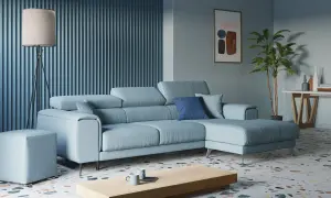 Accogliente soggiorno con divano azzurro, tavolino in legno, lampada da terra e un quadro astratto.