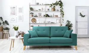 Un accogliente soggiorno con un divano verde acqua, mensole piene di oggetti decorativi e piante. Perfetto per creare abbinamenti di stile.