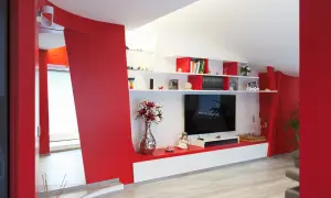 Pareti soggiorno rosso e grigio con mobile TV, libreria e decorazioni.