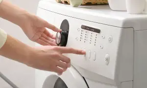Mani impostano la lavatrice, scegliendo il programma e la durata centrifuga lavatrice.