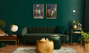 Elegante soggiorno con divano verde, tavolini dorati e due quadri classici che creano un contrasto moderno.