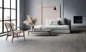 Soggiorno moderno con divano grigio chiaro, un tavolino e un pavimento in legno grigio.