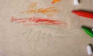 Tracce di pennarelli colorati su tela grezza, con macchie di pennarello secche che raccontano un momento creativo.