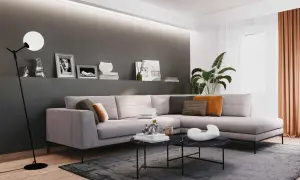 Illuminazione sopra divano, con lampada da terra moderna e faretti a soffitto che creano un'atmosfera accogliente.