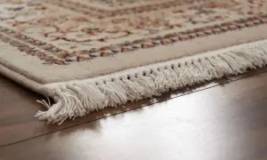 Dettaglio di un tappeto persiano con frange bianche, pronto per la pulizia professionale per mantenerne la bellezza.
