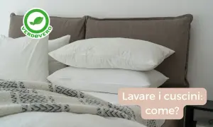 Bianchi cuscini su un letto, pronti per essere lavati in lavatrice. Scopri come lavare i cuscini per un sonno fresco e igienico.