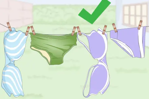 Biancheria intima appesa ad asciugare dopo il lavaggio in lavatrice. Un segno di spunta verde indica che è stato fatto correttamente.