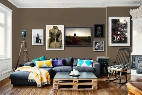 Divano blu scuro con cuscini colorati e coperta gialla. Abbinamenti moderni e accoglienti.