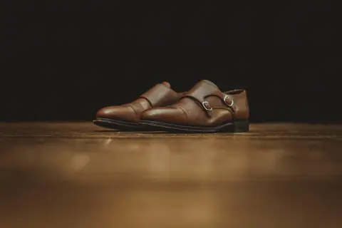 Scarpe eleganti in pelle marrone con doppia fibbia, perfette per chi vuole imparare come verniciare la pelle e dare nuova vita al proprio guardaroba.