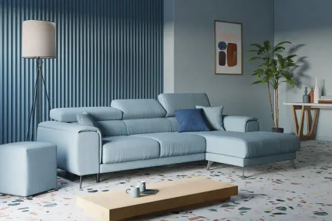 Accogliente soggiorno con divano azzurro, tavolino in legno, lampada da terra e un quadro astratto.