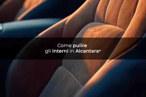 Dettaglio di sedili auto in materiale alcantara, con luce calda che ne esalta la texture.