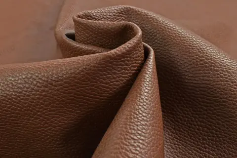 Tessuto di pelle pieno fiore marrone, con una texture granulosa che ne esalta il significato di qualità e naturalezza.
