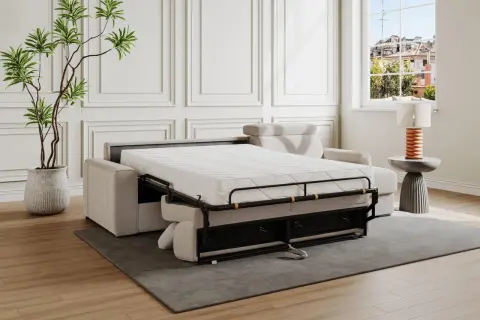 Divano letto aperto, pronto per la riparazione del meccanismo. Materasso bianco, struttura metallica nera, cuscini beige.
