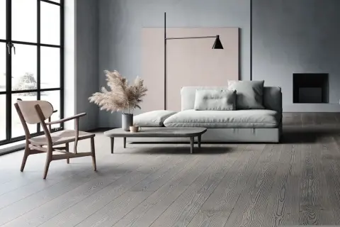 Soggiorno moderno con divano grigio chiaro, un tavolino e un pavimento in legno grigio.