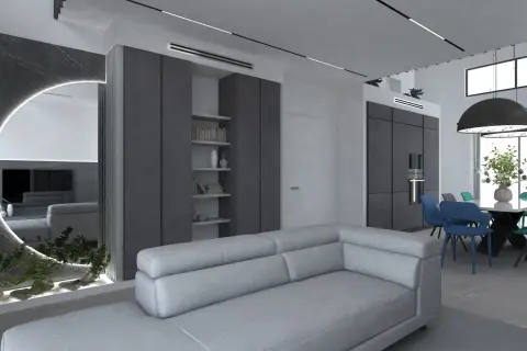 Un soggiorno moderno con divano grigio chiaro, pareti in vari tipi di grigio, specchio circolare illuminato e zona pranzo con sedie colorate.