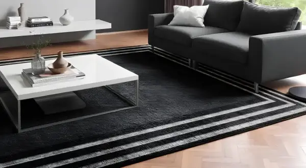Un elegante soggiorno con un divano grigio e un tavolino bianco. Il pavimento è coperto da un tappeto nero con strisce bianche, perfetto per accostare due tappeti e creare un ambiente moderno.