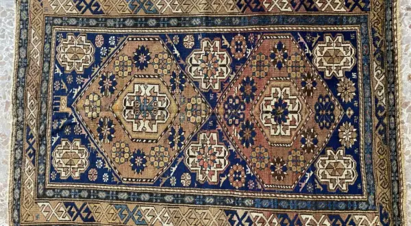 Tappeti Shirvan con motivi geometrici esagonali e floreali su sfondo blu e marrone. Bordi decorati con motivi a zig-zag.