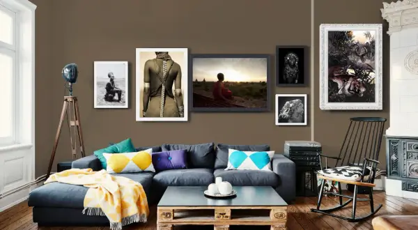Divano blu scuro con cuscini colorati e coperta gialla. Abbinamenti moderni e accoglienti.