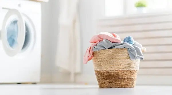Cesto di biancheria colorata pronto per il lavaggio. Scopri come far profumare il bucato con trucchi semplici e naturali.