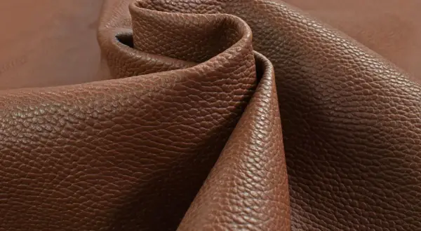 Tessuto di pelle pieno fiore marrone, con una texture granulosa che ne esalta il significato di qualità e naturalezza.