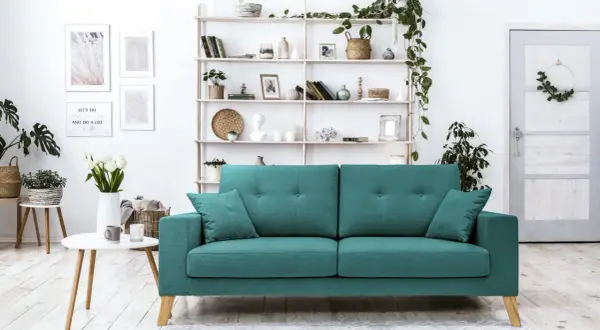 Un accogliente soggiorno con un divano verde acqua, mensole piene di oggetti decorativi e piante. Perfetto per creare abbinamenti di stile.