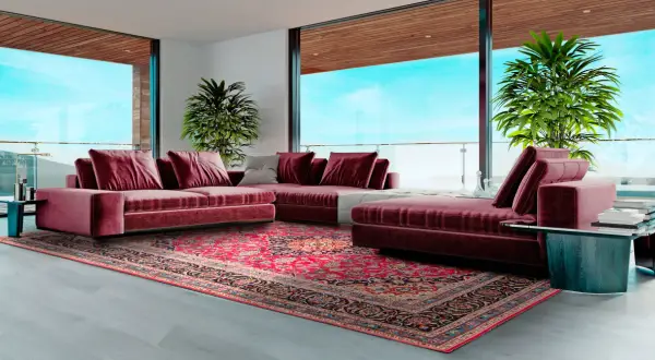 Soggiorno moderno con divano bordeaux e un tappeto persiano dai colori vivaci, che mostra diversi tipi di tappeti persiani.