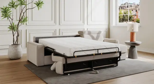 Divano letto aperto, pronto per la riparazione del meccanismo. Materasso bianco, struttura metallica nera, cuscini beige.