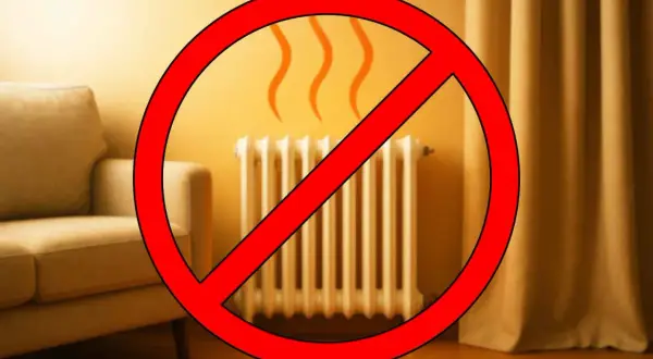 Divano accostato al termosifone, con un grande segnale di divieto rosso sopra.