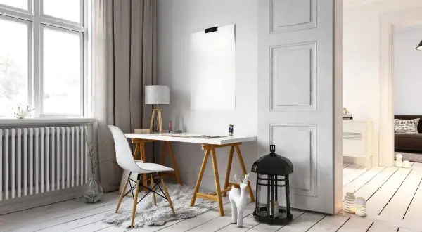 Scrivania con sedia bianca e lampada, accanto a un termosifone. Idee per come arredare parete con termosifone, con decorazioni minimaliste.