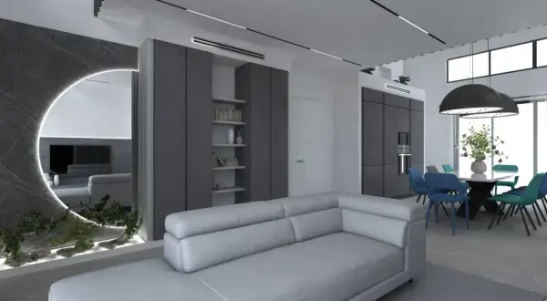 Un soggiorno moderno con divano grigio chiaro, pareti in vari tipi di grigio, specchio circolare illuminato e zona pranzo con sedie colorate.