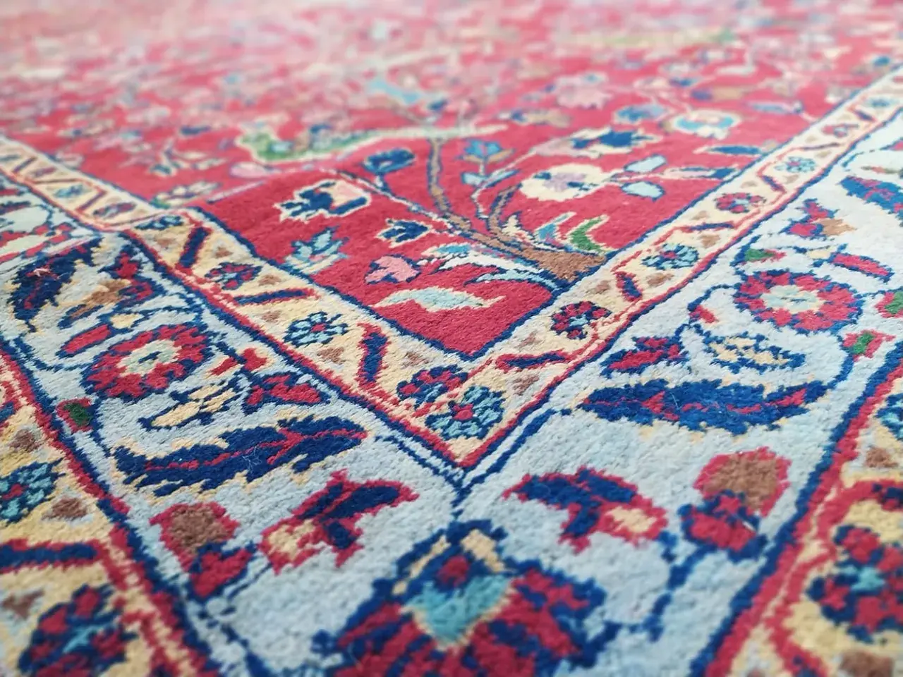 Tappeto Tabriz usato, con dettagli floreali rossi e blu su fondo chiaro. Ottimi prezzi per questo pezzo d'arte.