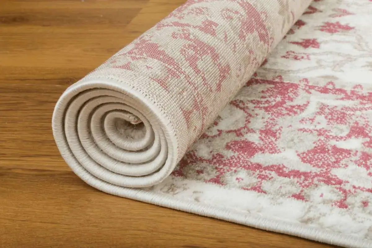 Tappeto persiano arrotolato su parquet. Scopri come conservare i tappeti persiani per mantenerli come nuovi.
