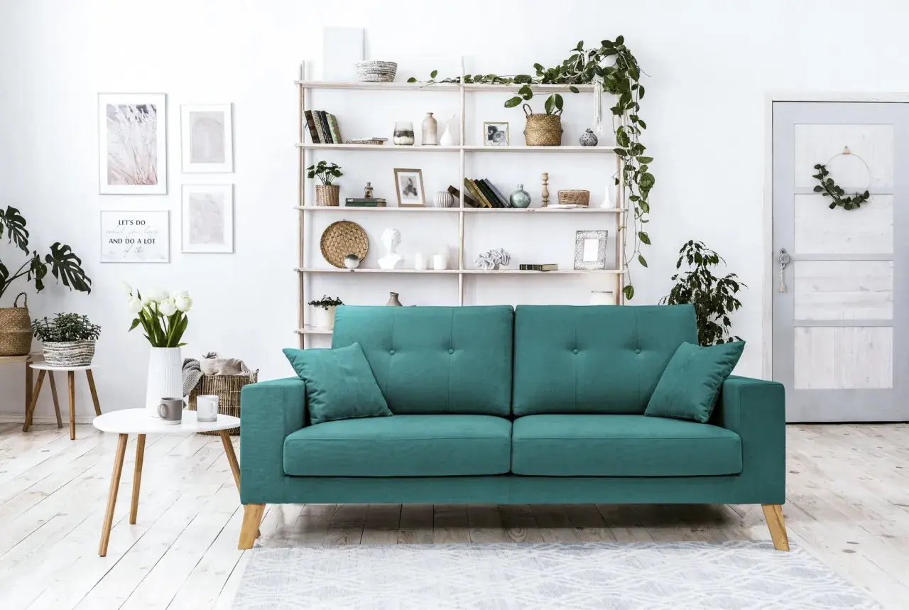 Un accogliente soggiorno con un divano verde acqua, mensole piene di oggetti decorativi e piante. Perfetto per creare abbinamenti di stile.
