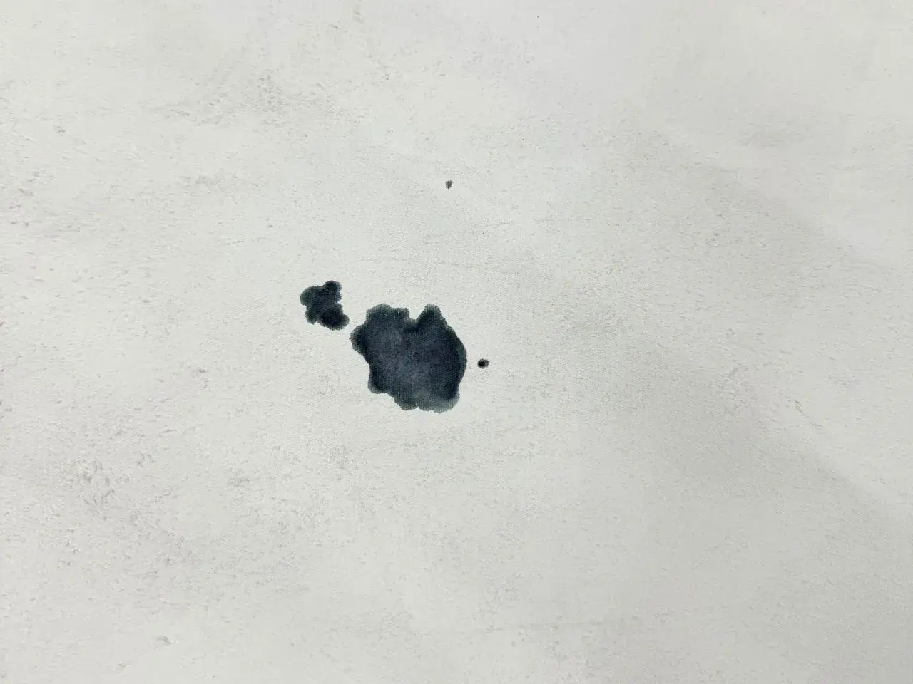 Macchie scure su tessuto bianco, un esempio di come togliere la muffa dalla pelle.