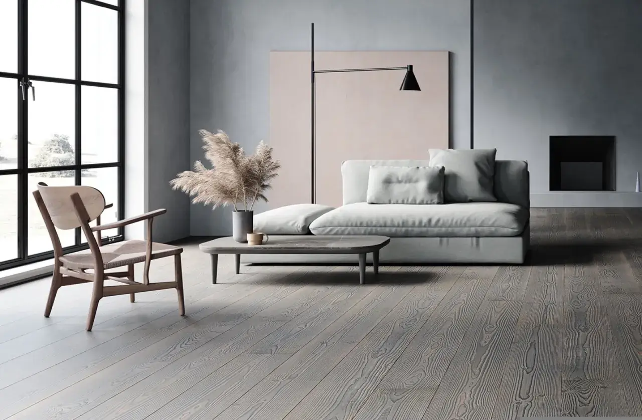 Soggiorno moderno con divano grigio chiaro, un tavolino e un pavimento in legno grigio.