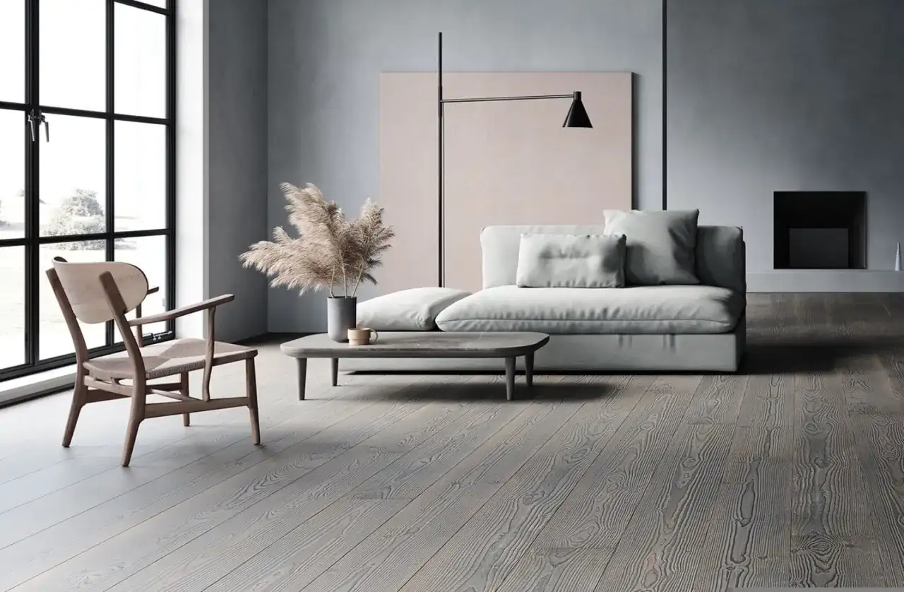 Soggiorno moderno con divano grigio chiaro, un tavolino e un pavimento in legno grigio.