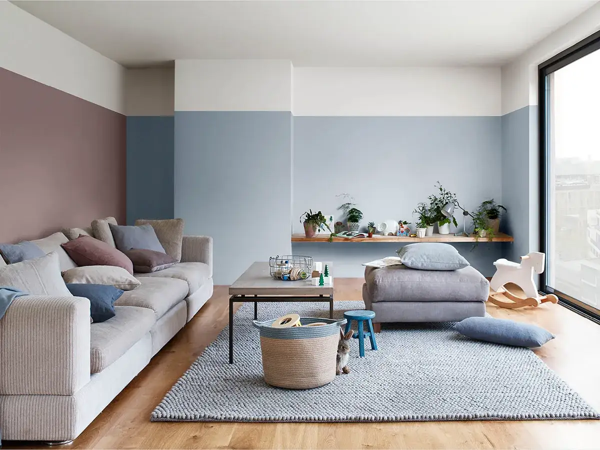 Salotto moderno con divano beige, tavolino e un morbido tappeto color carta da zucchero che invita al relax.
