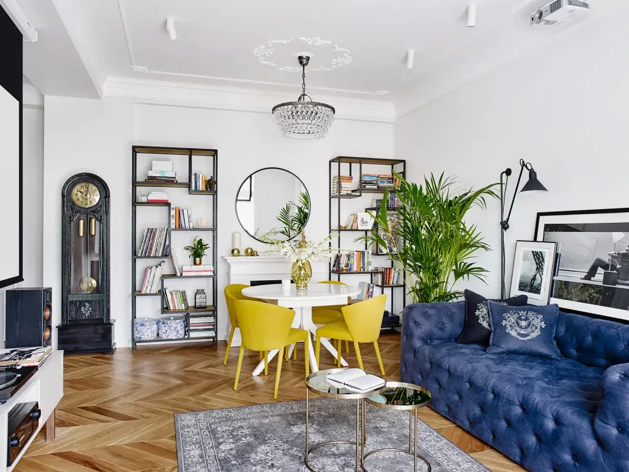 Un elegante soggiorno con un blu scuro divano blu abbinamenti perfetti con i dettagli dorati e i cuscini decorativi.