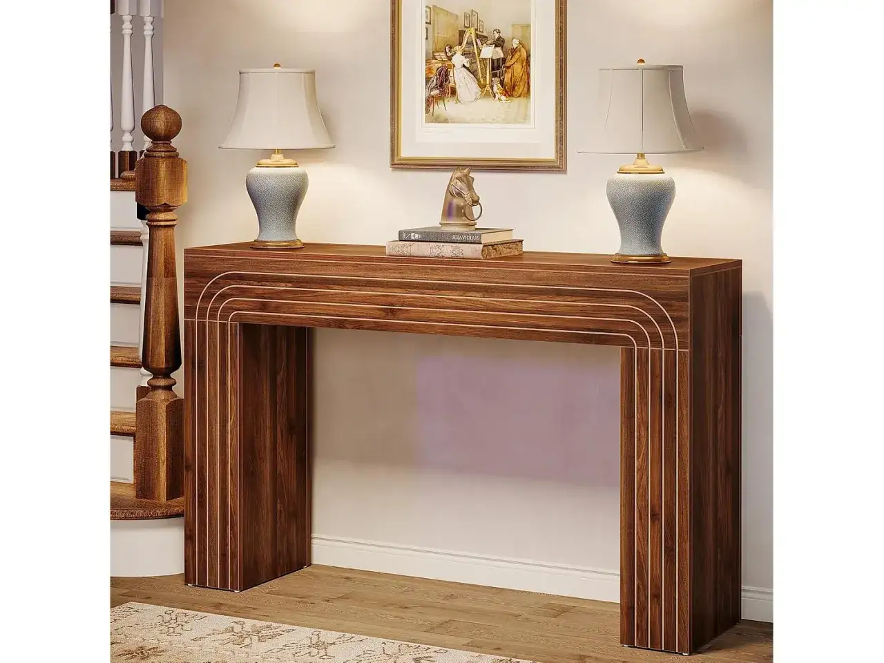 Un tavolino stretto in legno scuro, ideale per arredare l'ingresso o come soluzione per cosa mettere dietro al divano, con due lampade e un quadro.
