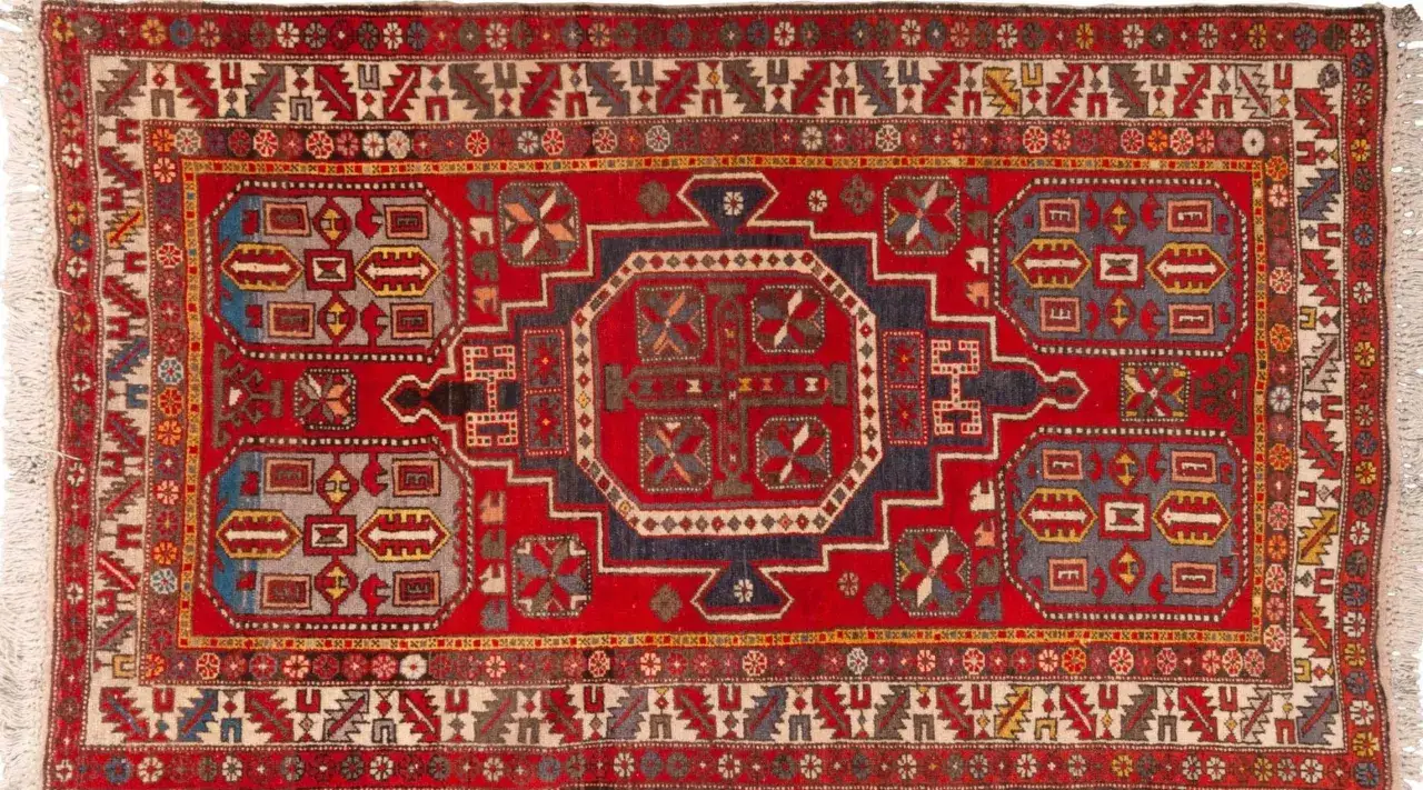 Tappeti armeni con motivi geometrici rossi, blu e grigi su sfondo rosso. Un disegno centrale ottagonale circondato da forme rettangolari e romboidali.