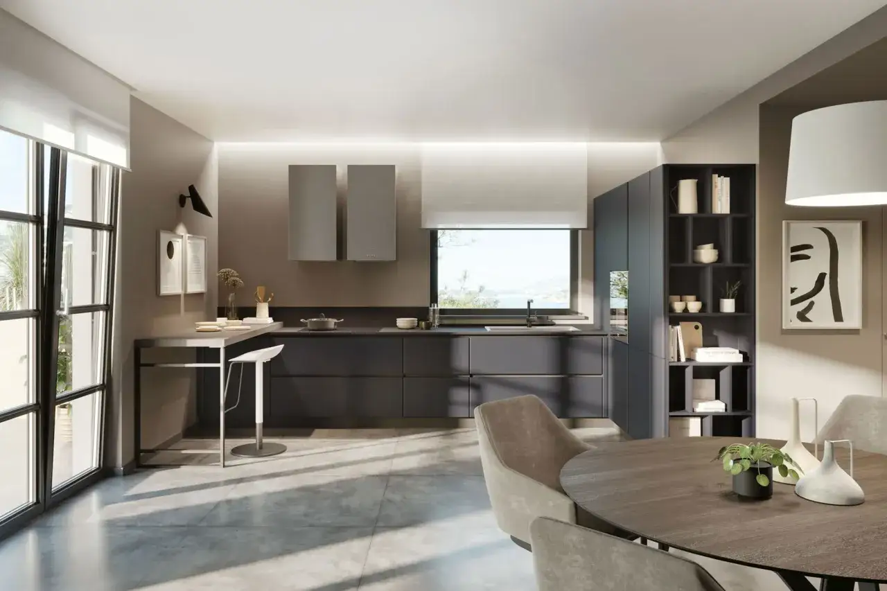 Cucina moderna con isola, mobili grigio antracite e dettagli in vari tipi di grigio. Tavolo rotondo e sedie in tessuto completano l'ambiente.