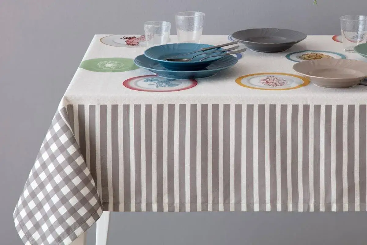Tovaglia a quadri e righe con piatti decorati. Scopri come lavare le tovaglie in lavatrice per mantenerle sempre perfette.