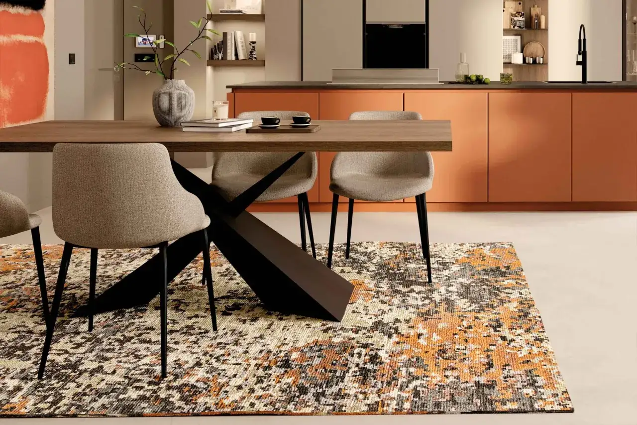Tavolo da pranzo moderno con sedie e un tappeto pregiato moderno dai colori vivaci che aggiunge un tocco di calore all'ambiente.