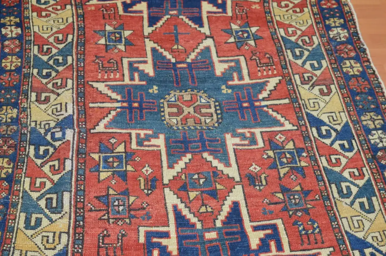 Tappeti Shirvan con motivi geometrici rossi, blu e gialli. Un disegno centrale a stella circondato da simboli e animali stilizzati.